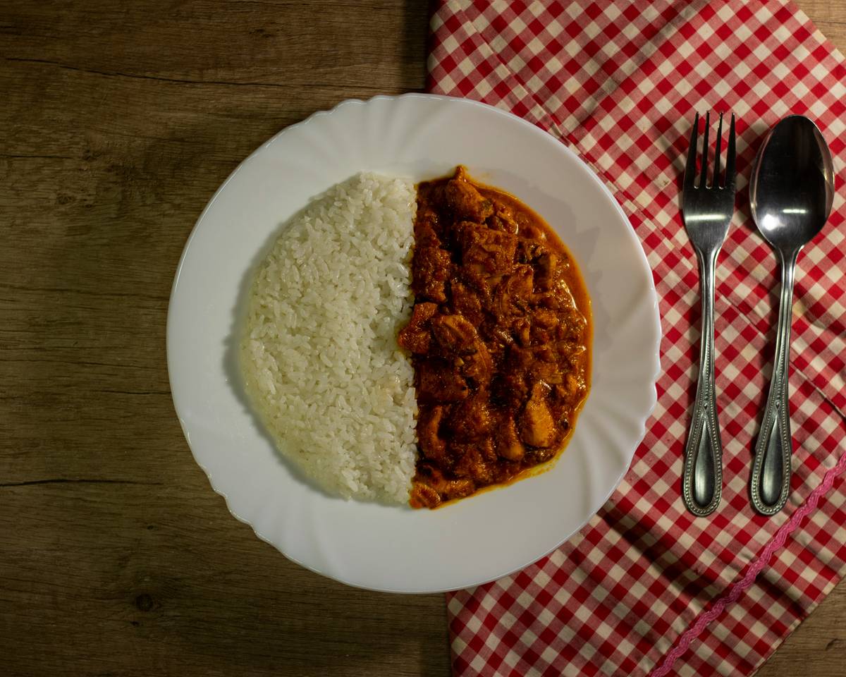 A photo showing a journal placed beside a delicious-looking wellness meal plate containing grilled chicken and quinoa.